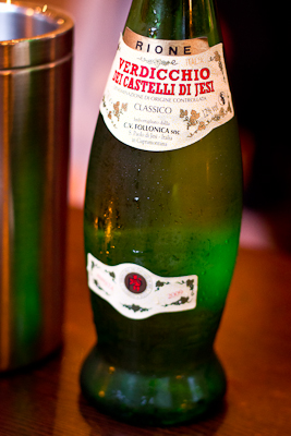 A curiously-shaped bottle of verdicchio beside a wine-cooler in Branca Restaurant, Oxford
