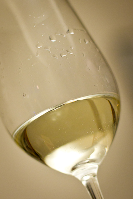 A tilted glass of pale white wine