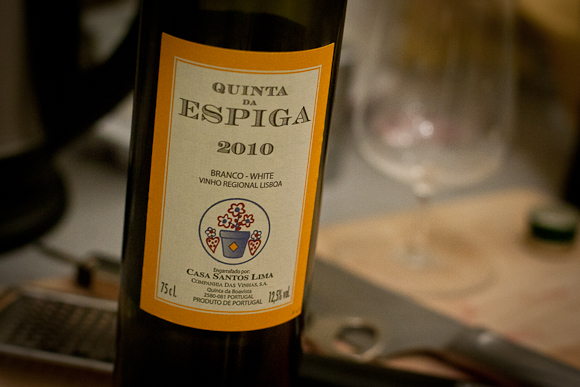 A shot of the (yellow) label of a bottle of this Portuguese white. In the background, a glass (out of focus), chopping board and cutlery