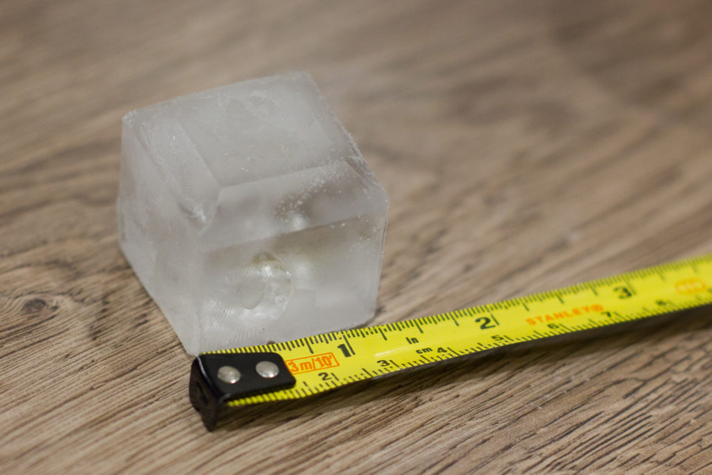 Chunky ice cube alongside a tape measure. It's about 3cm cubed.