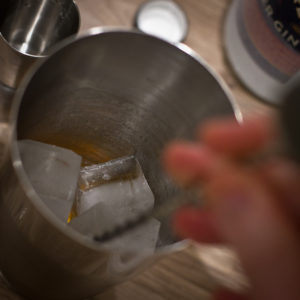 Stirring a cocktail shaker filled with ice to make a Martinez
