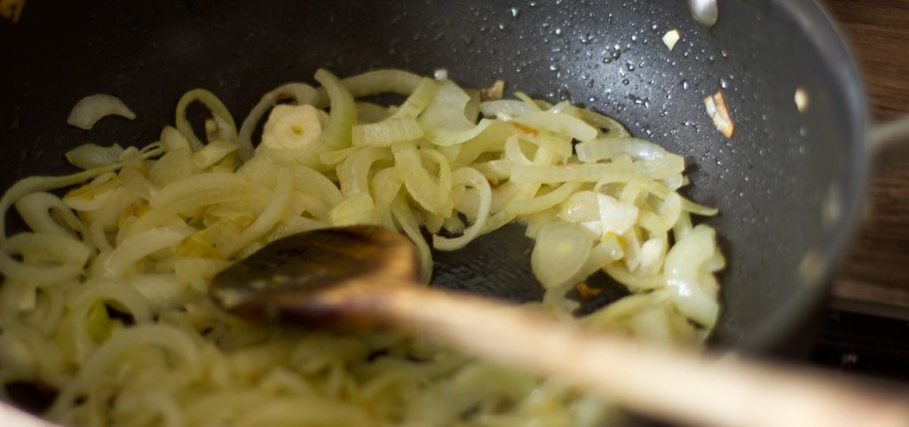 Onions frying with garlic in a pan